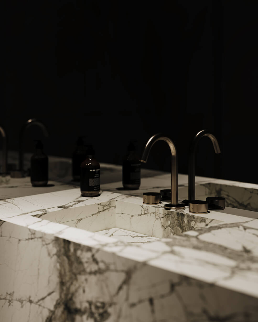 Marmurowa umywalka z dwoma kranami i butelkami kosmetyków. /034 lipova