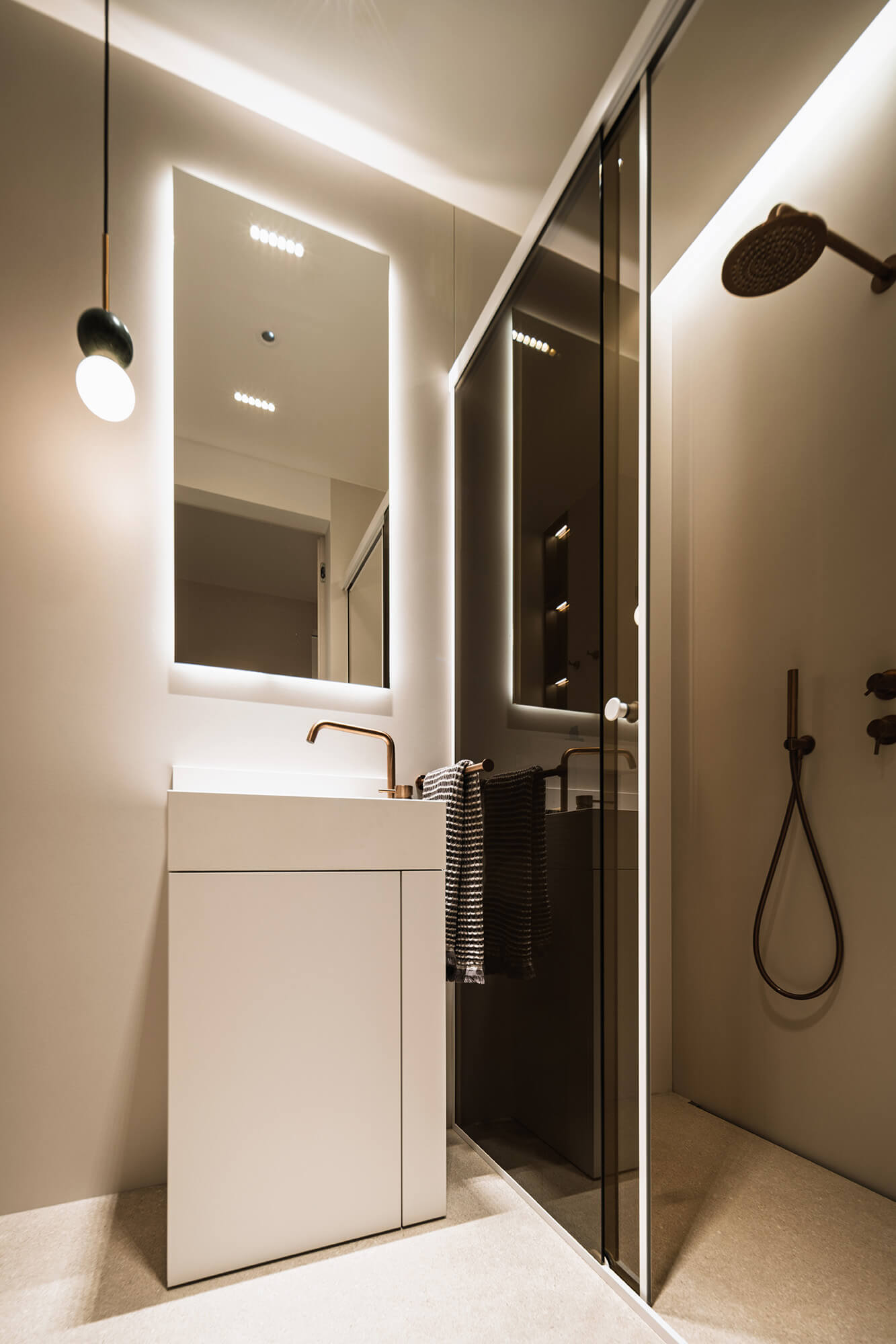 Elegancka łazienka z umywalką, lustrem z podświetleniem LED i kabiną prysznicową. Nowoczesny design.