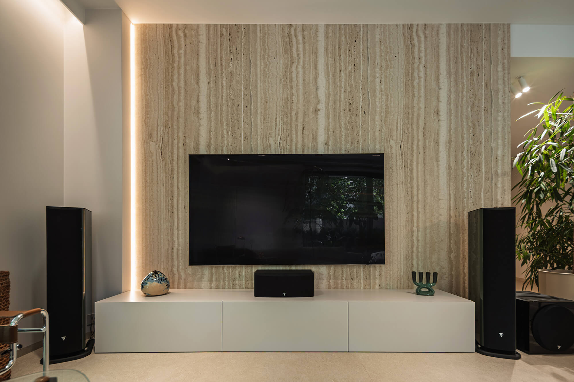 Elegancki salon z telewizorem, głośnikami i kamienną ścianą. Nowoczesne wnętrze.