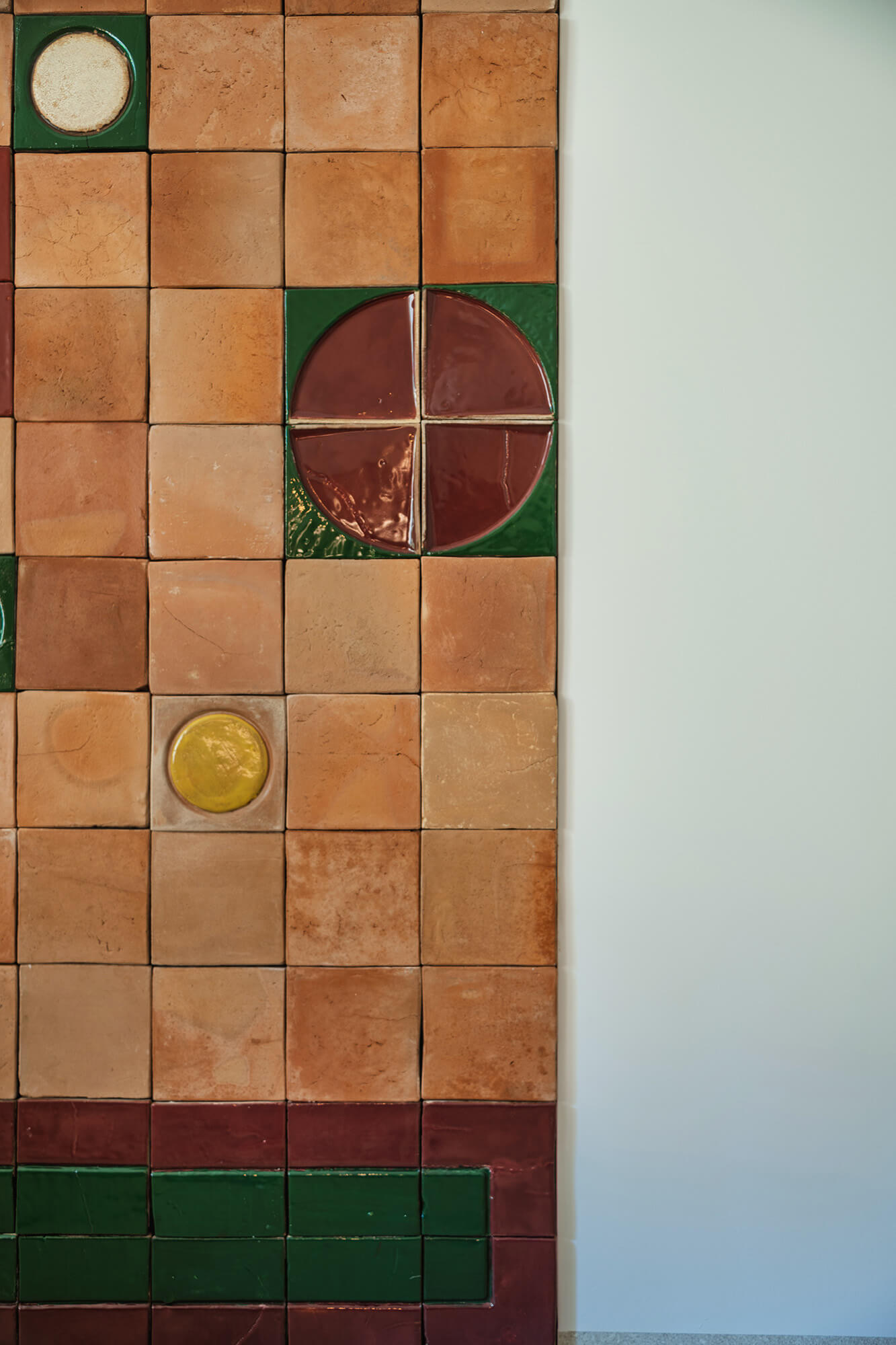 Ściana z terakotowych płytek z geometrycznymi wzorami. Detal architektoniczny.