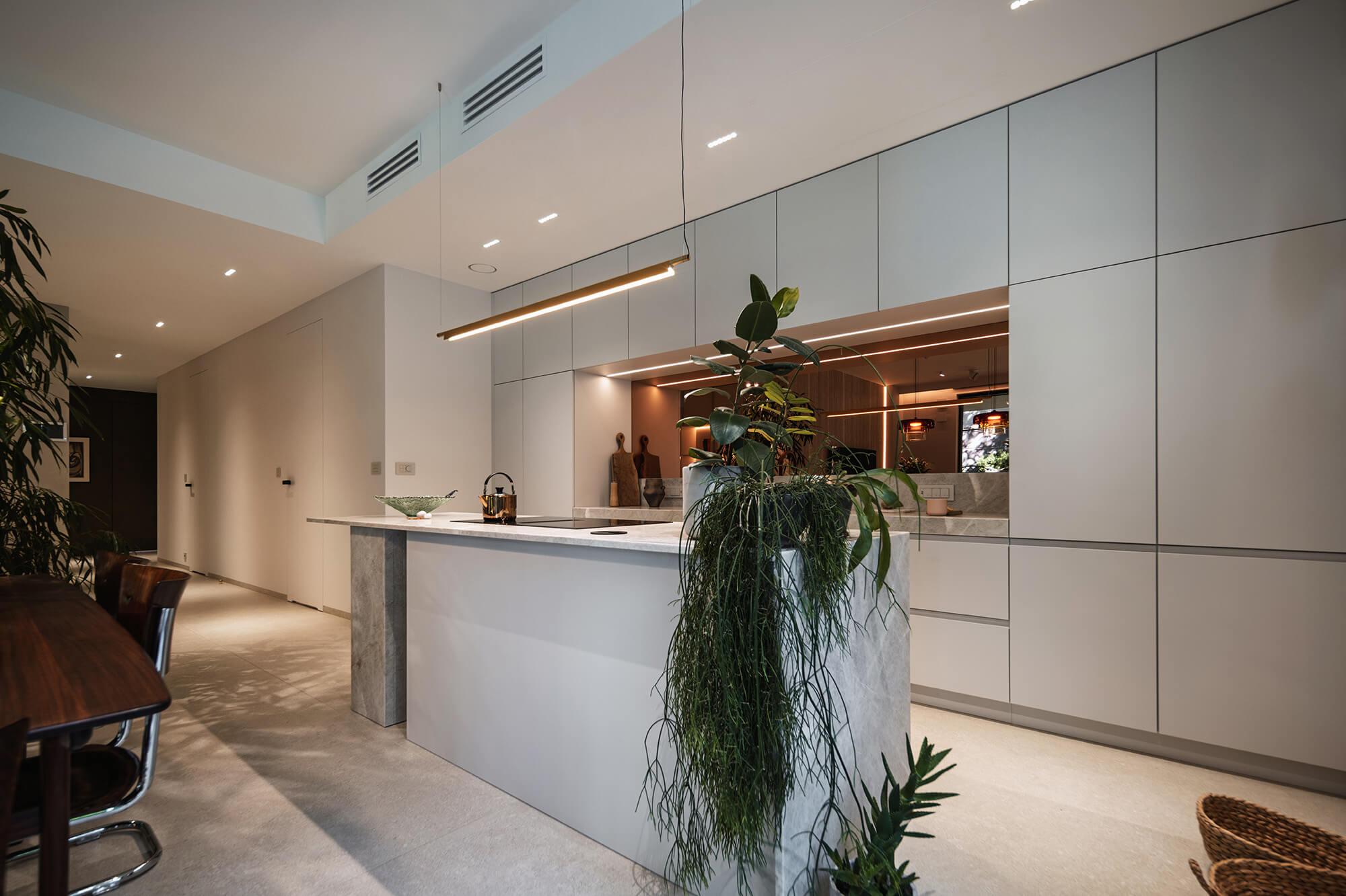 Modern sustainable kitchen with island, plants, and eco-friendly materials.