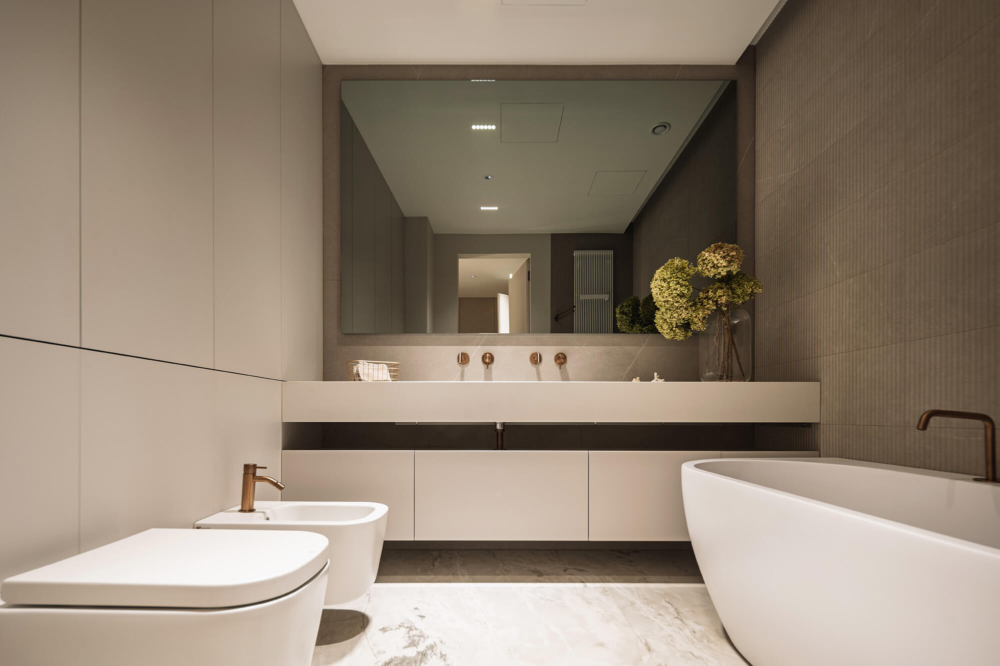 Nowoczesna łazienka z wanną, bidetem i marmurową podłogą. Minimalistyczny design.