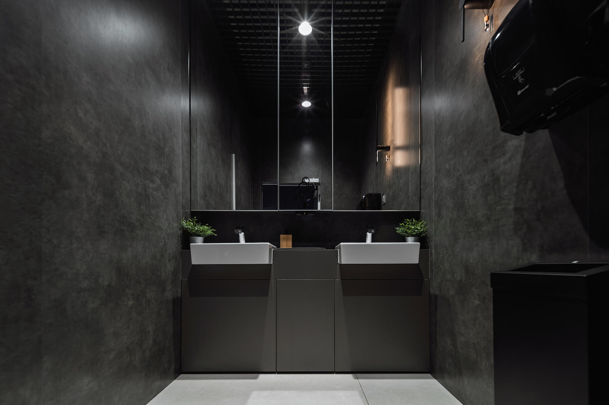 Nowoczesna łazienka w ciemnych kolorach z podwójną umywalką i dużym lustrem.