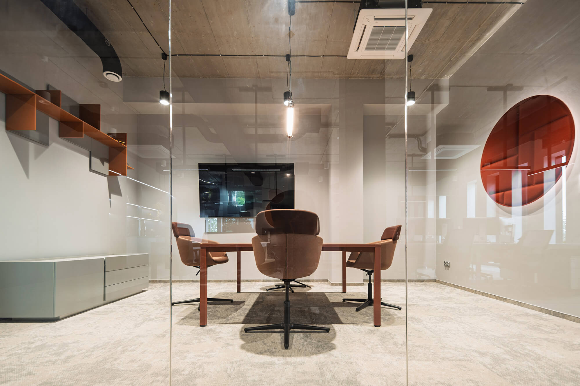 Sala konferencyjna z szklanymi ścianami, stołem i krzesłami. Nowoczesne biuro.