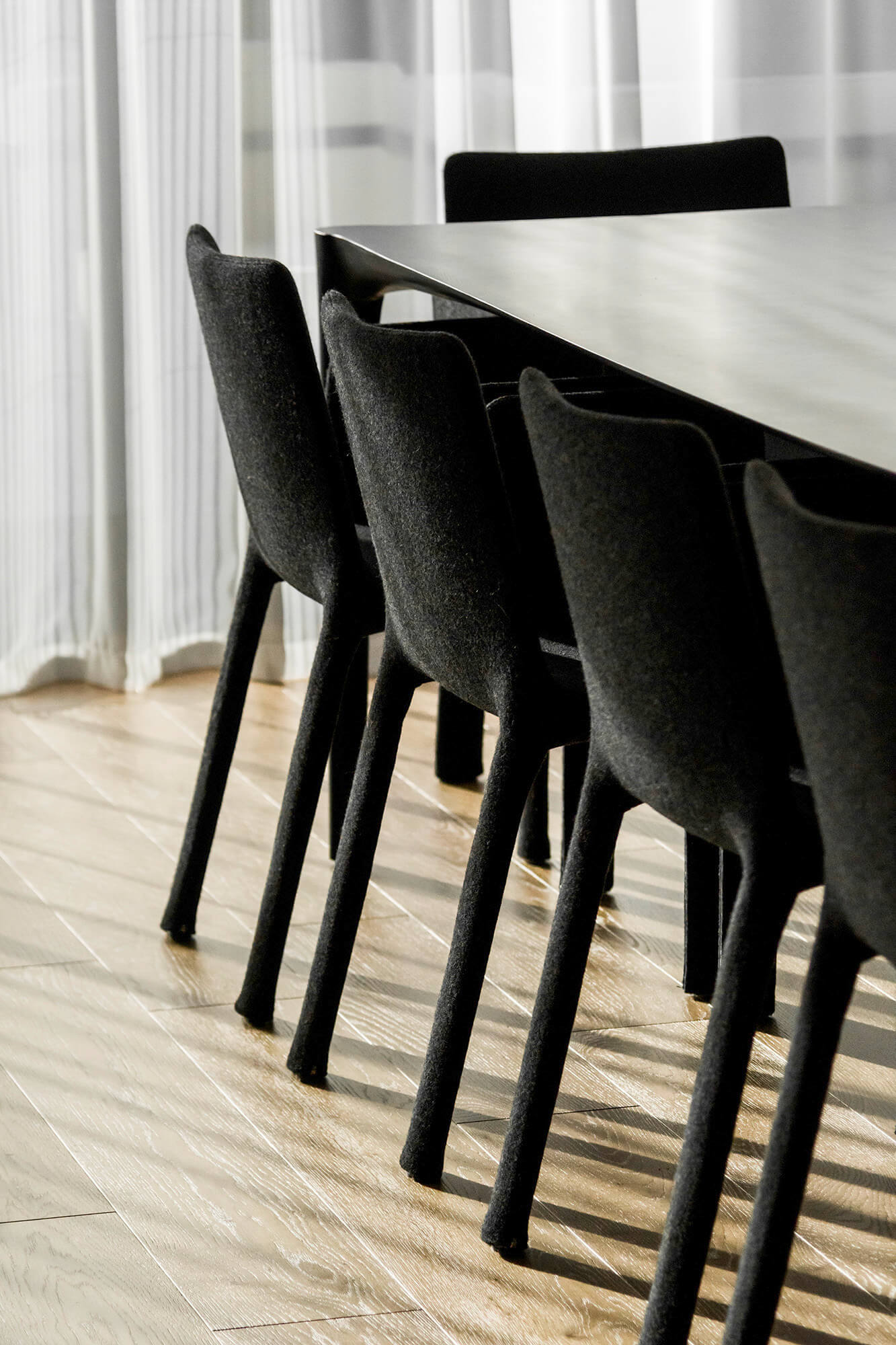 Czarne krzesła przy stole w nowoczesnym wnętrzu. Minimalistyczny design, eleganckie meble.