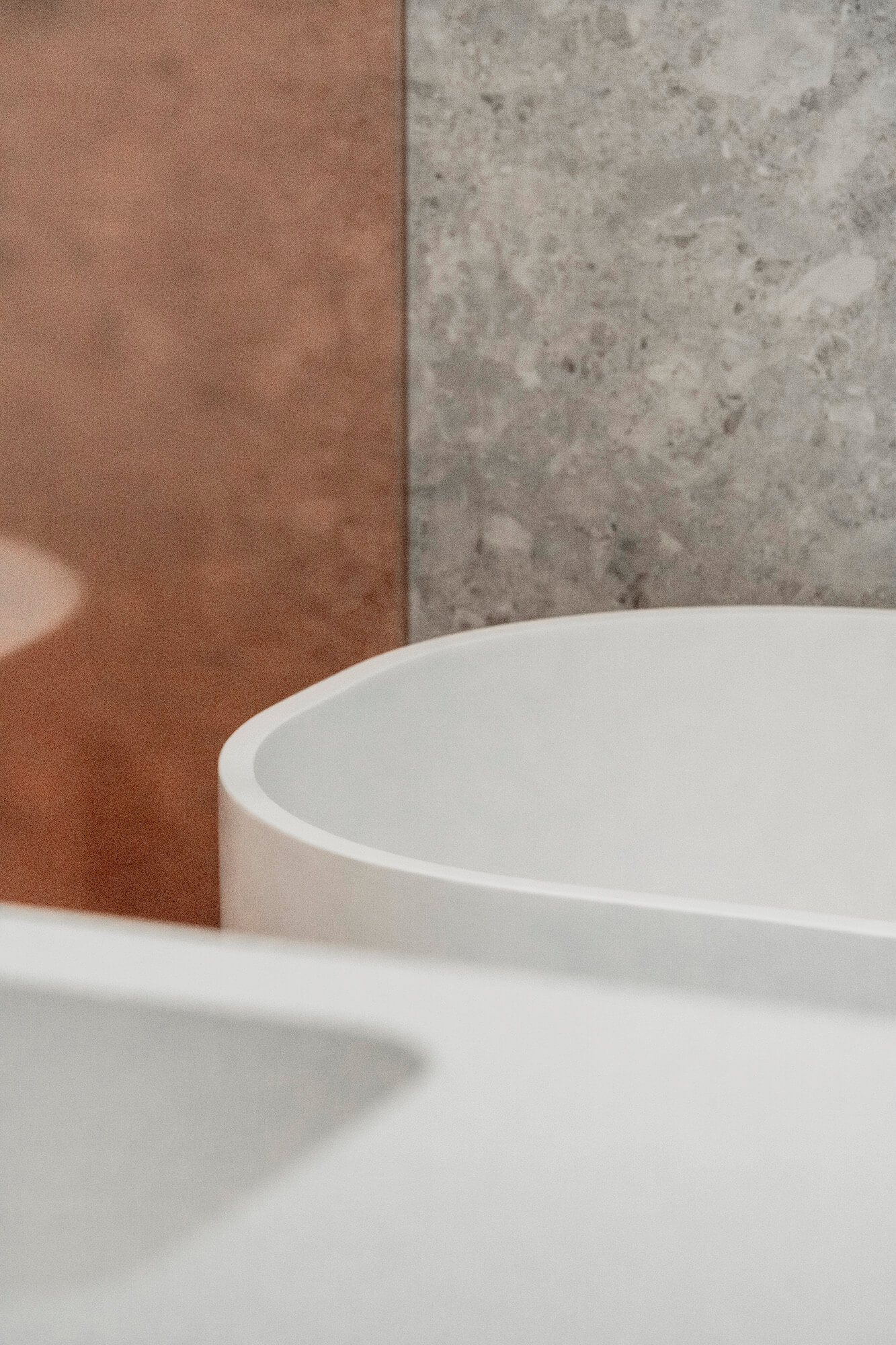 Biała wanna na tle ściany z marmuru i miedzi.