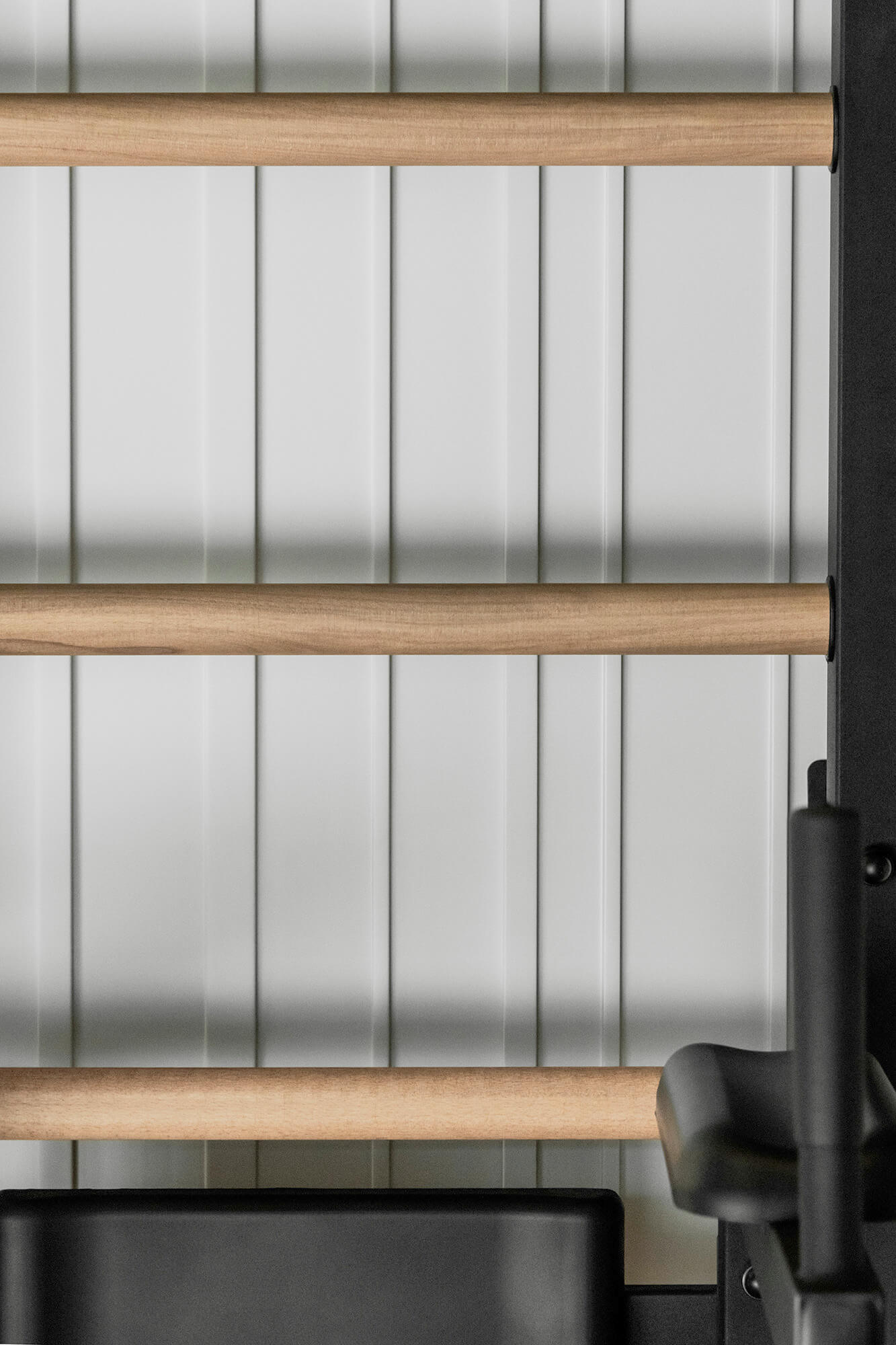 Drabinka gimnastyczna z drewnianymi szczeblami na białej ścianie. Sprzęt do ćwiczeń.