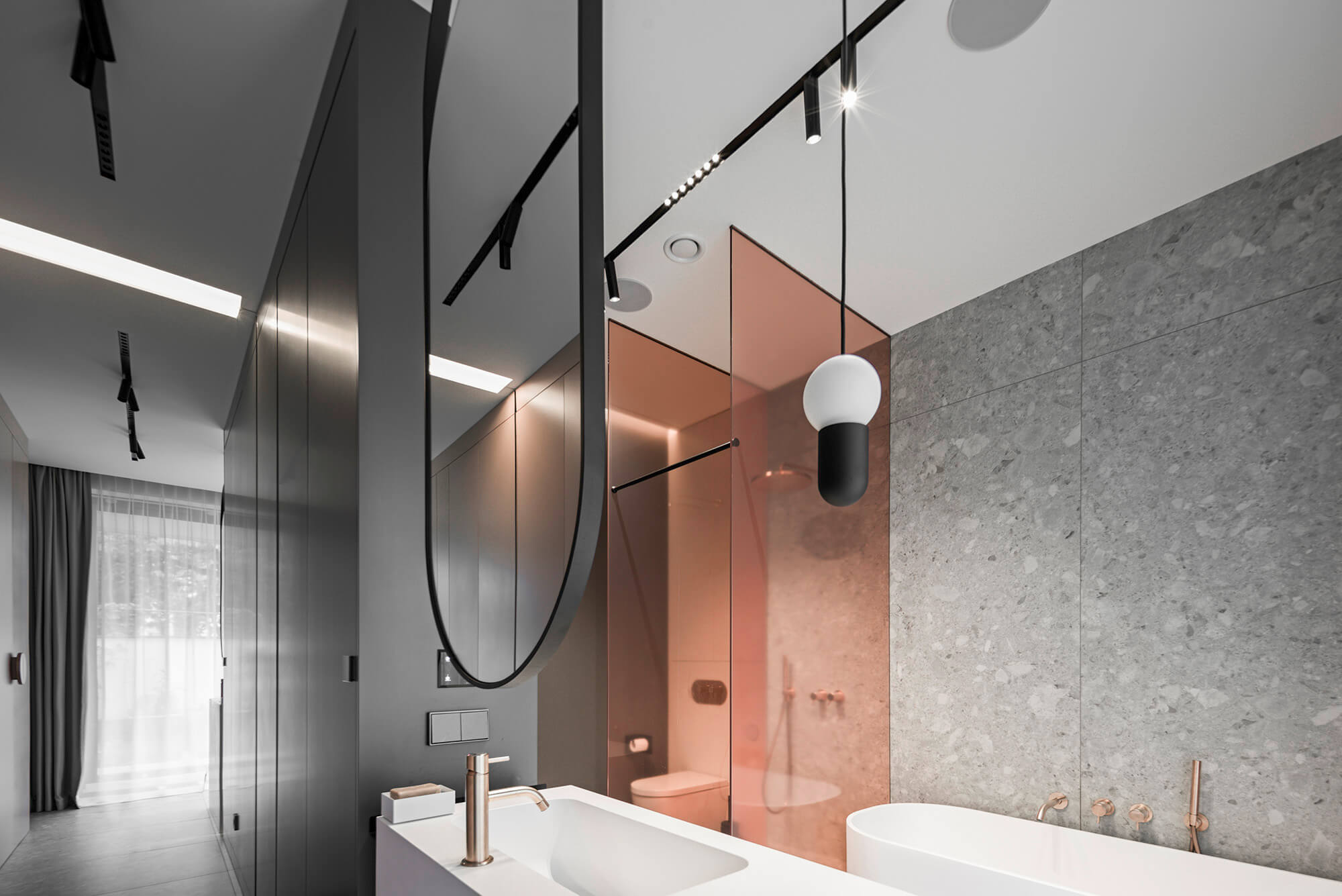 Sleek modern bathroom with minimalist design, gray tile, and unique bathroom lighting.