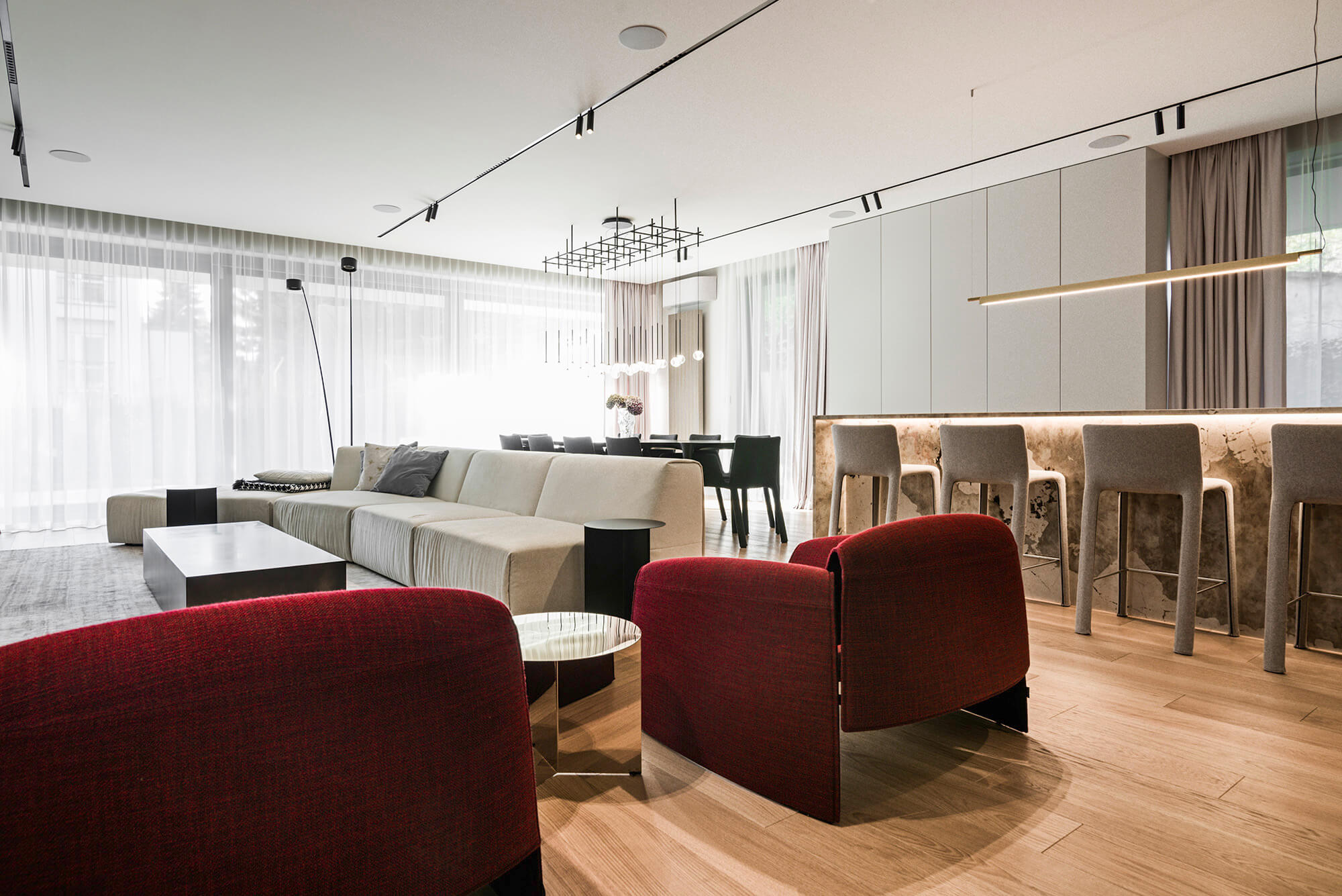 Nowoczesny salon z sofą, krzesłami i barem. Jasne wnętrze.