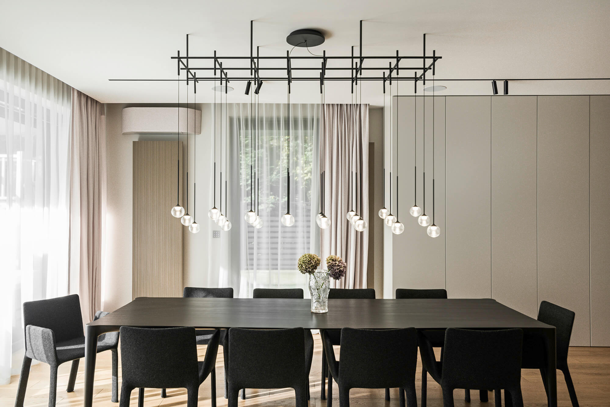 Nowoczesna jadalnia: czarny stół, krzesła i designerska lampa z kulami. Minimalistyczne wnętrze.