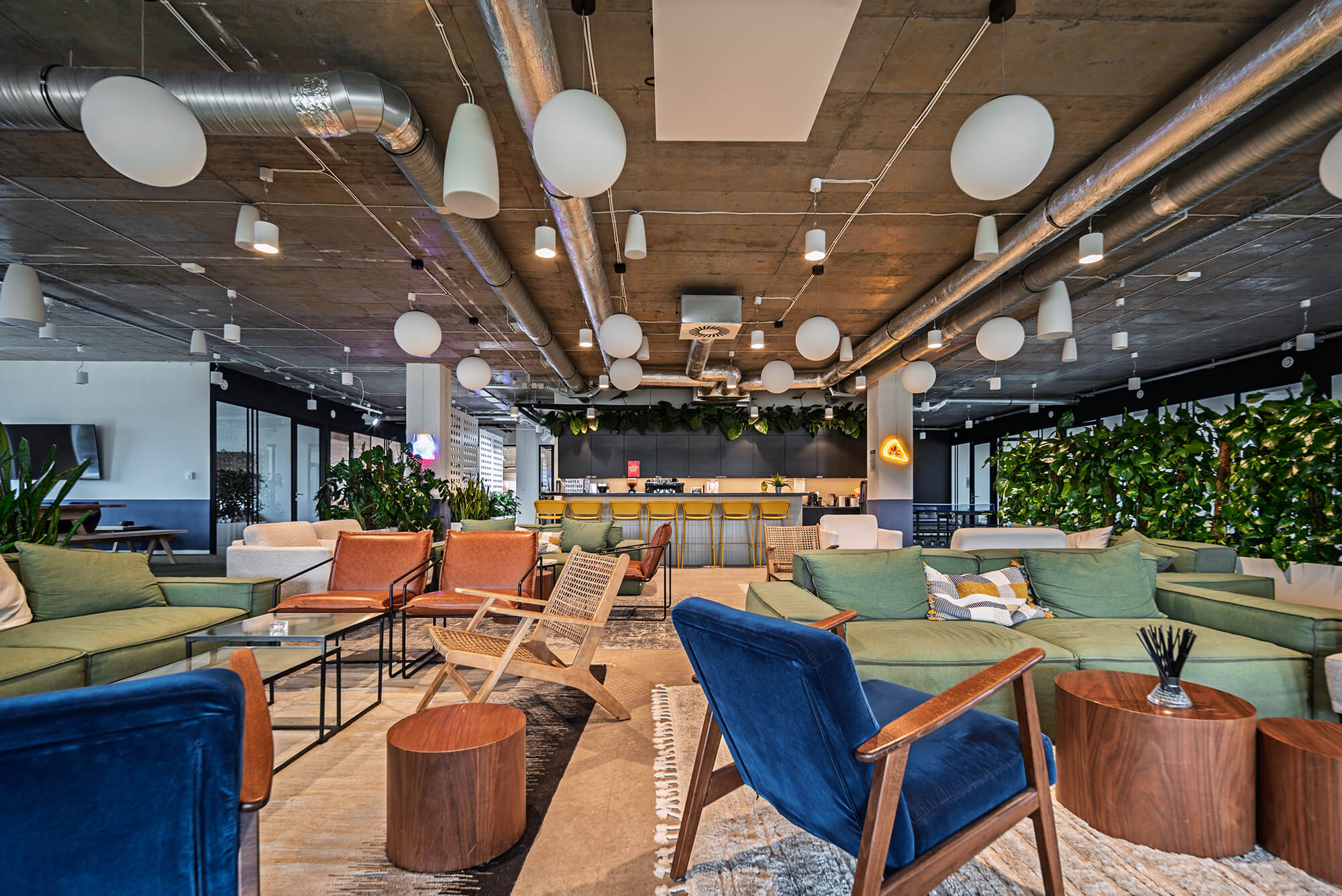 Wnętrze nowoczesnego biura z sofami, krzesłami i lampami w stylu loft.