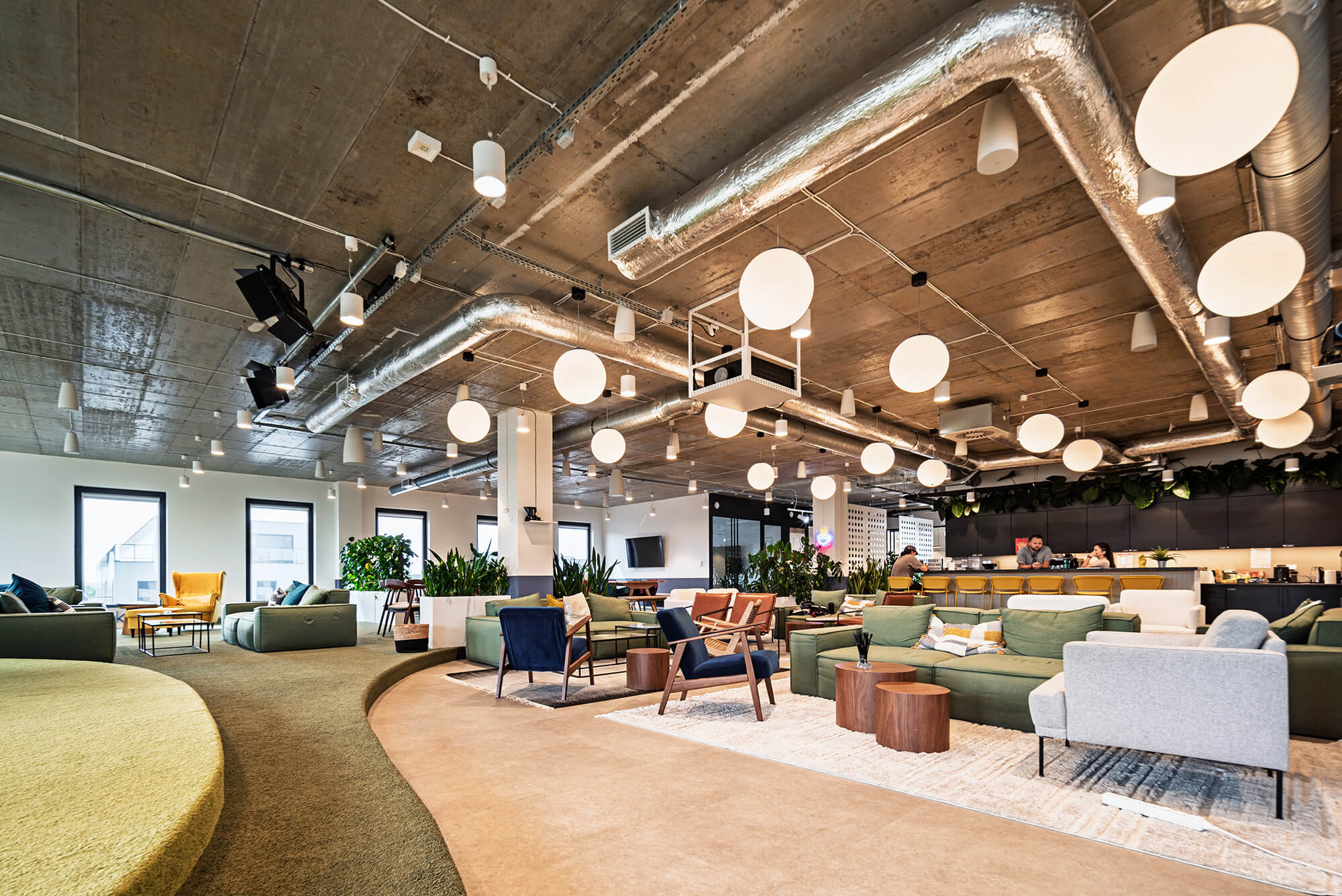 Bright open office with collaborative workspace and lounge area.