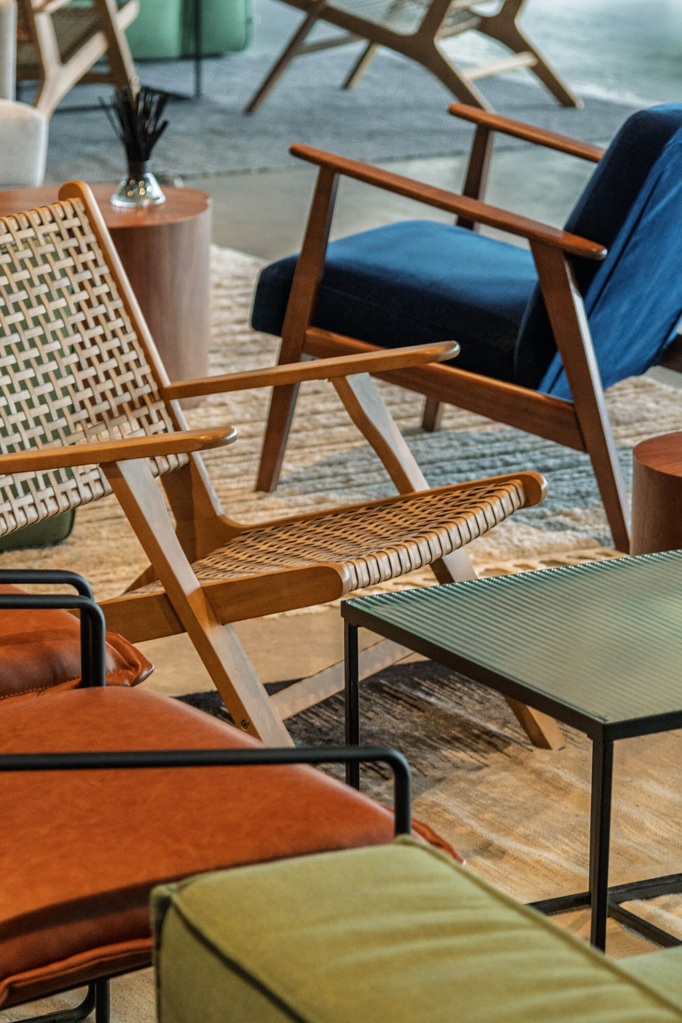 Fotele z drewna i wikliny na dywanie. Wygodne siedziska w salonie.