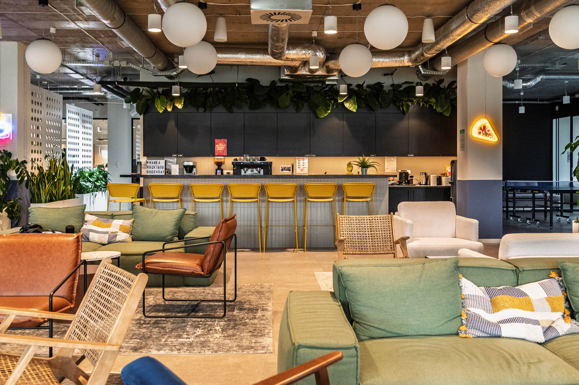 Modern office space featuring biophilic design with plants, natural light, and sustainable furniture.