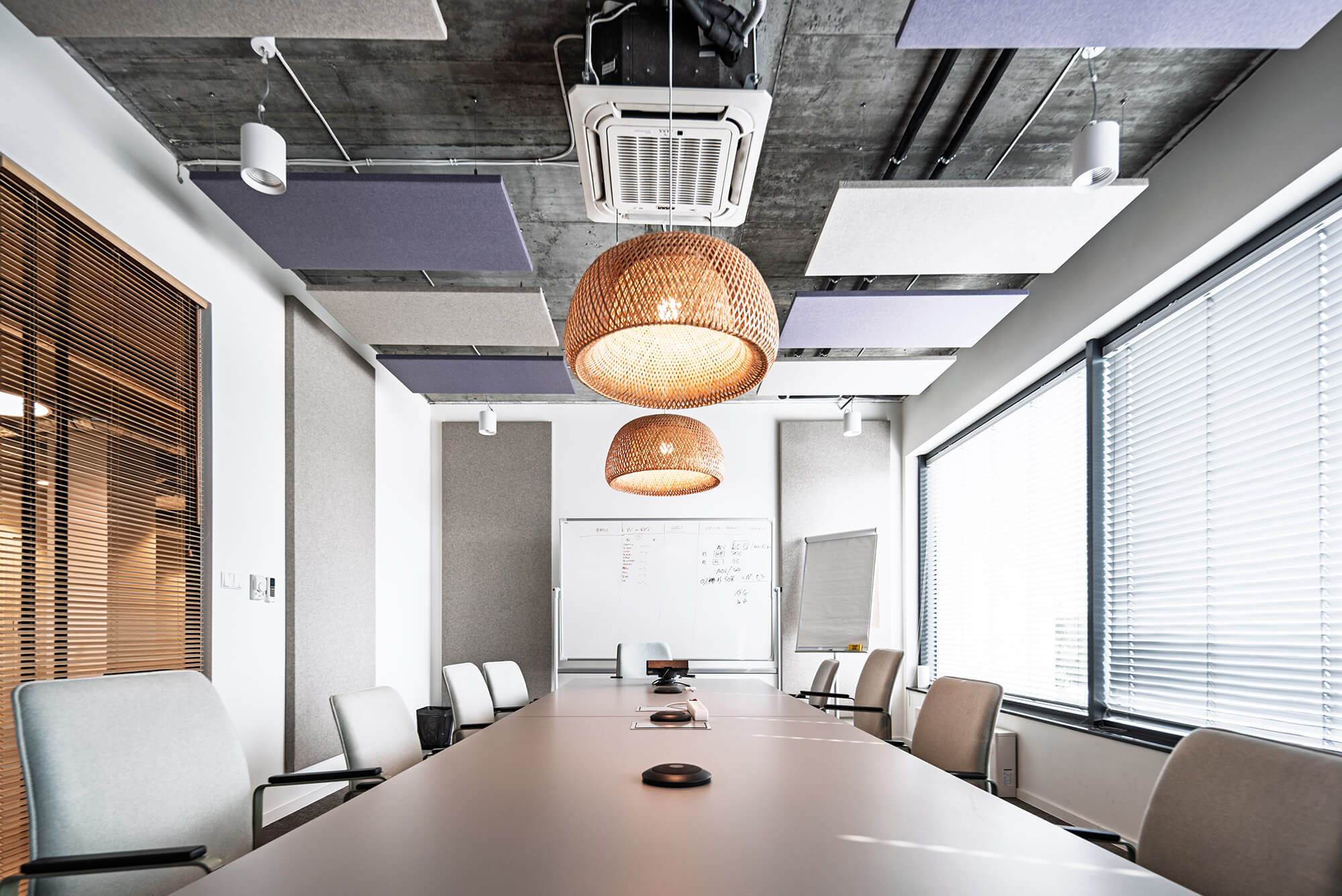 Nowoczesna sala konferencyjna z długim stołem, krzesłami i wiszącymi lampami