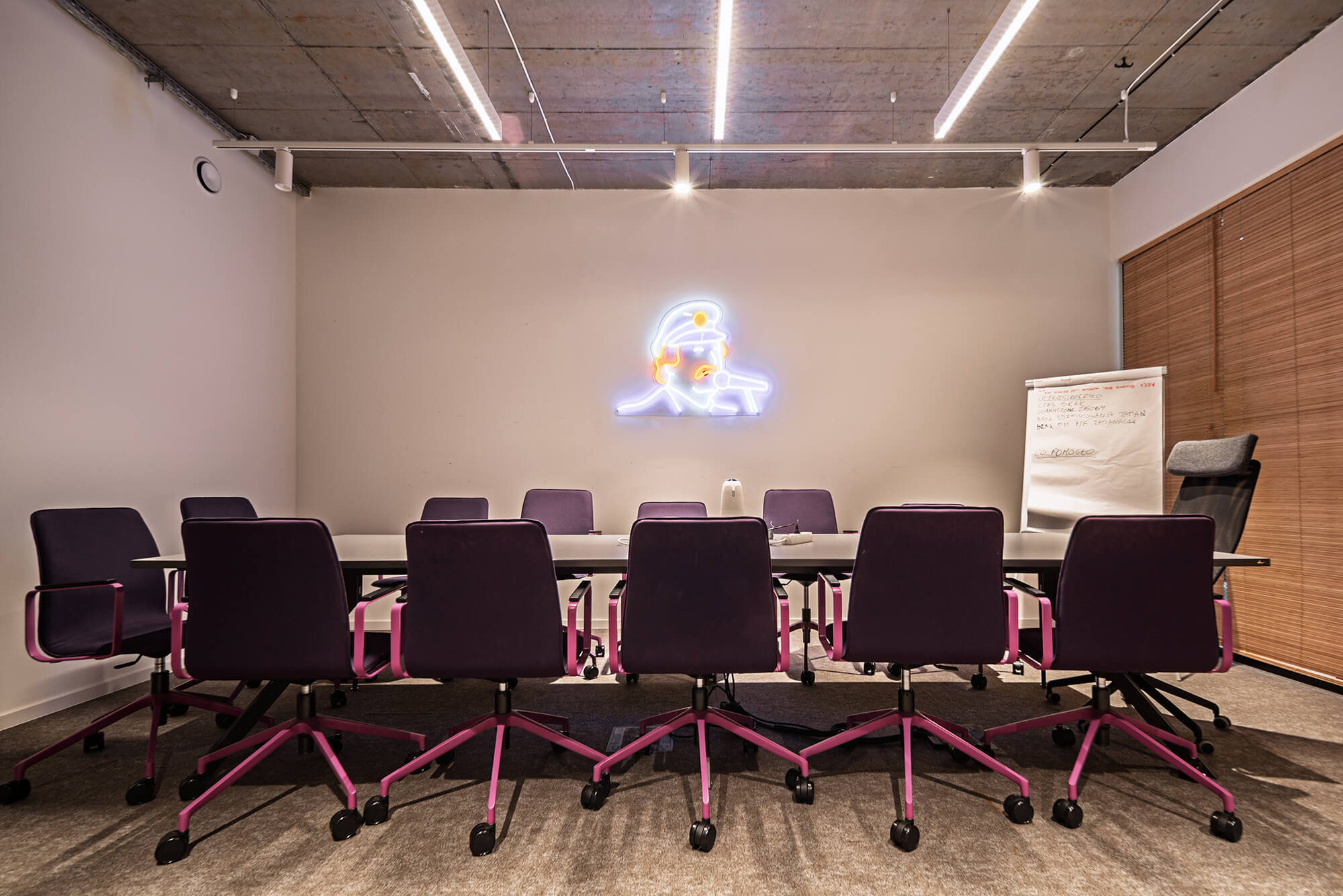 Sala konferencyjna z neonem, krzesła w kolorze fuksji. Nowoczesne biuro.