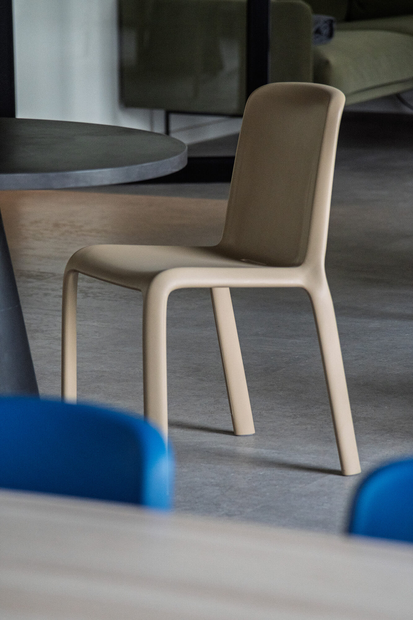 Beżowe krzesło w nowoczesnym wnętrzu. Minimalistyczny design, szara podłoga.