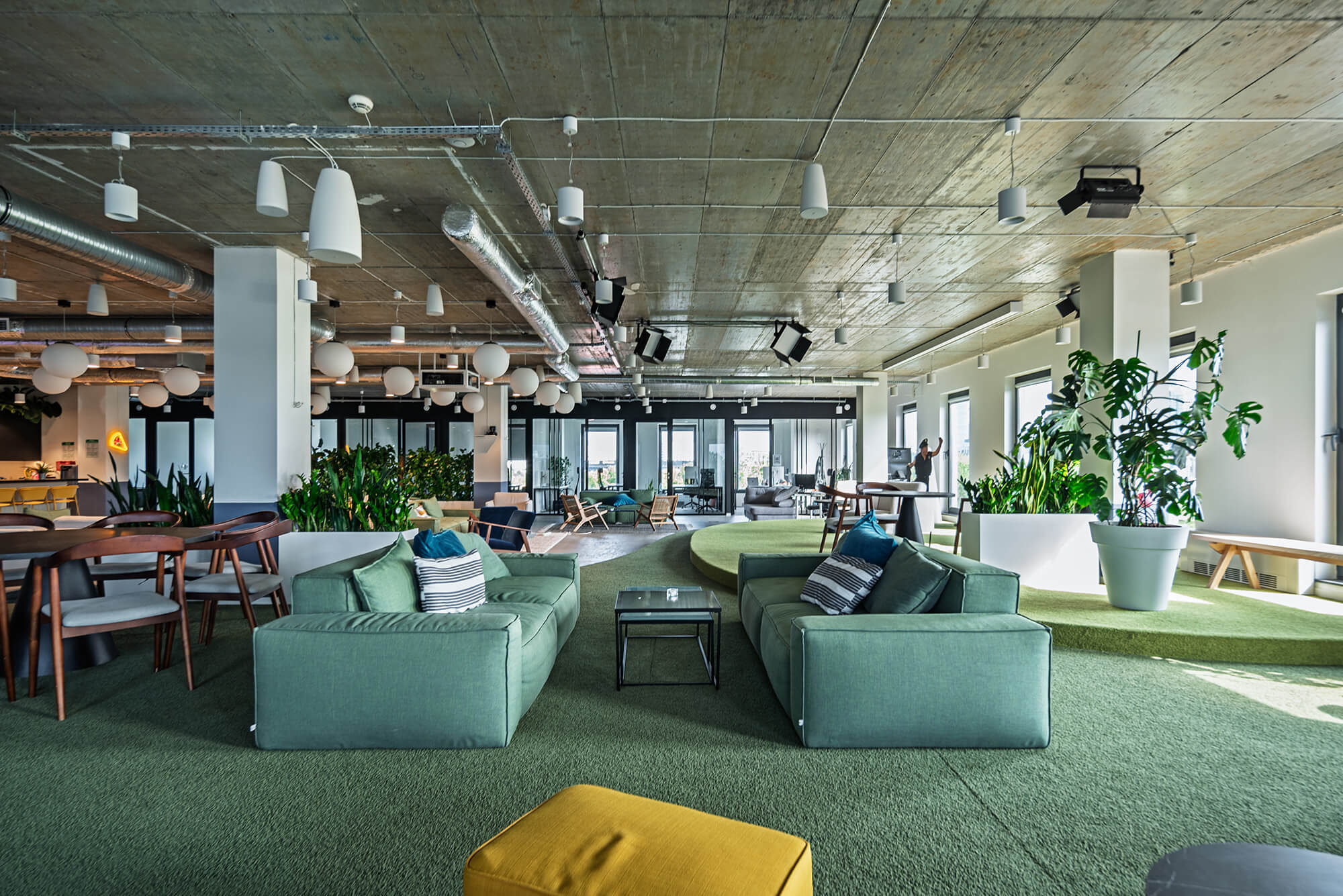 Nowoczesne biuro z zielonymi sofami i roślinami. Przestrzeń relaksu w biurze.
