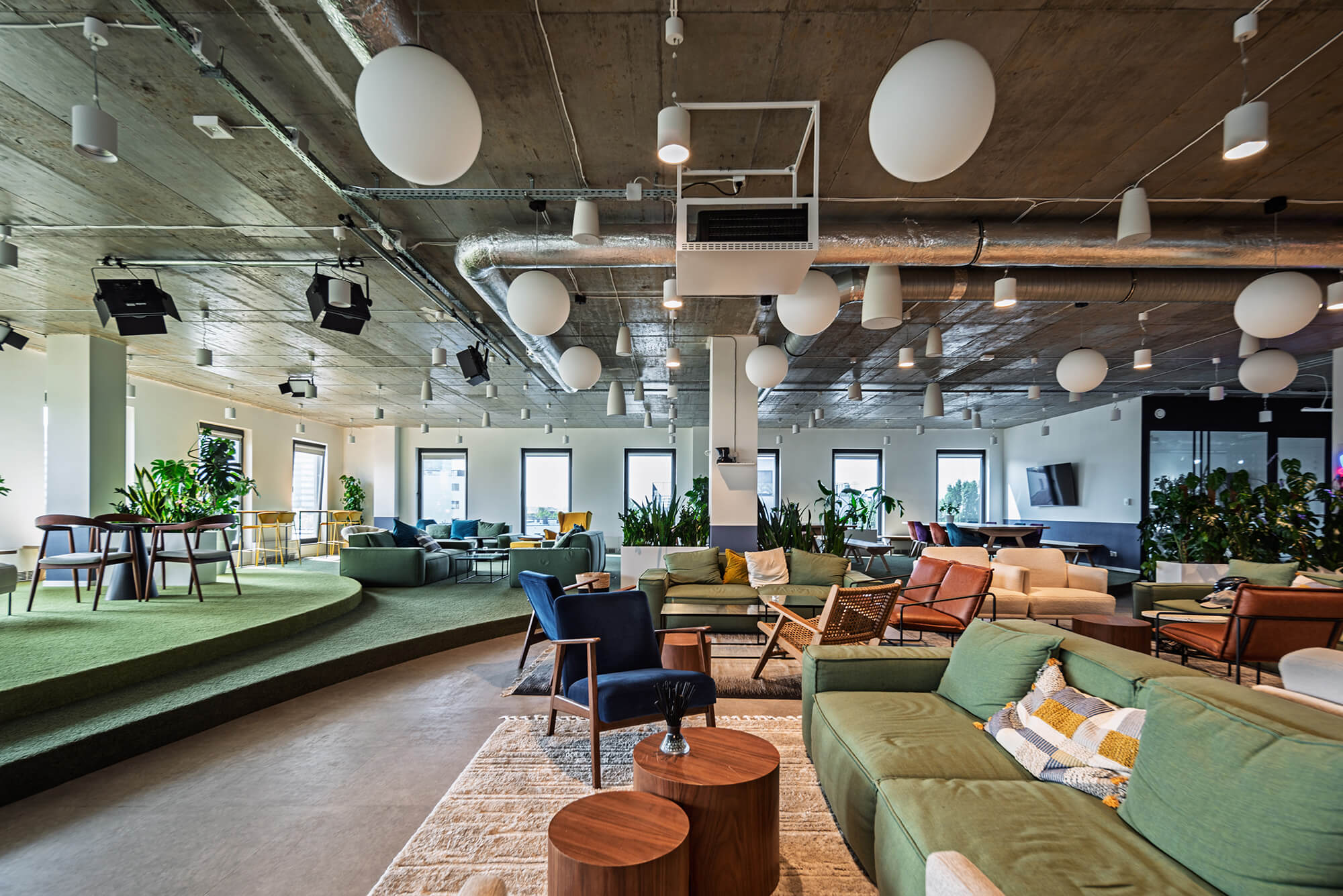 Przestronne, nowoczesne biuro z zieloną sofą i elementami wystroju. Nowoczesna przestrzeń biurowa.